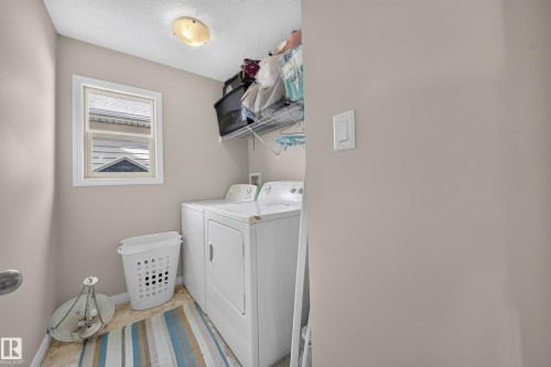 Laundry area featuring a window, overhead light fixture, and wire shelving - 1927 51 Street Sw, Edmonton, AB - Indoor Photo Showing Laundry Room