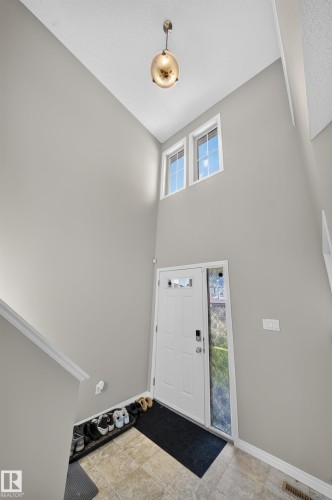 Entryway with tile flooring, a white paneled door with decorative glass, and a full-length sidelight - 1927 51 Street Sw, Edmonton, AB - Indoor Photo Showing Other Room
