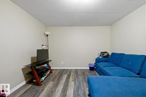 Neutral wall tones, wood-finish flooring, and white trim - 9712 162 St Nw, Edmonton, AB - Indoor Photo Showing Living Room