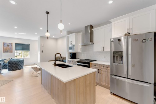 Open-concept living space featuring wood-finish flooring and recessed lighting - 1263 Watt Drive Sw, Edmonton, AB - Indoor Photo Showing Kitchen With Stainless Steel Kitchen With Double Sink With Upgraded Kitchen