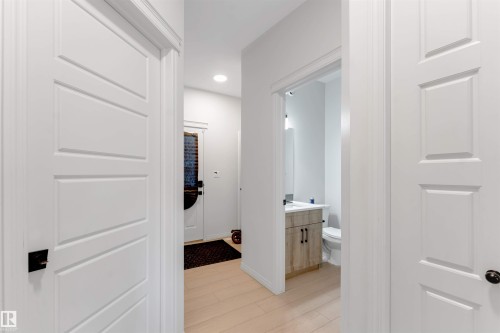 Light wood-finish flooring with white trim - 1263 Watt Drive Sw, Edmonton, AB - Indoor Photo Showing Other Room