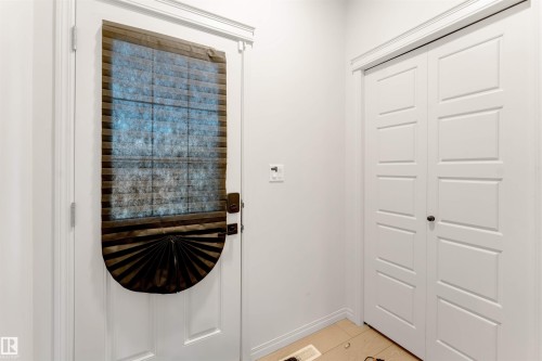 White paneled door with privacy shade, white walls, and light-toned tile flooring - 1263 Watt Drive Sw, Edmonton, AB - Indoor Photo Showing Other Room