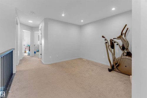 Carpeted floor, recessed lighting, white walls, and a black metal railing - 1263 Watt Drive Sw, Edmonton, AB - Indoor Photo Showing Other Room