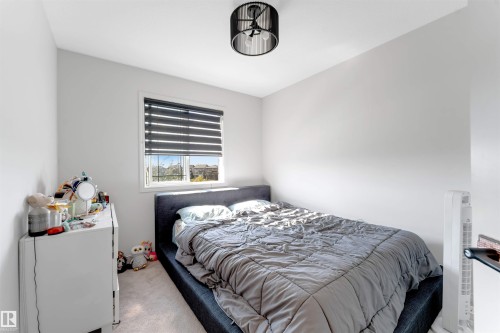 White walls, window with blinds, and a semi-flush mount ceiling light - 1263 Watt Drive Sw, Edmonton, AB - Indoor Photo Showing Bedroom