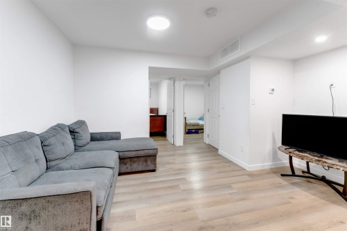 Light wood-finish flooring, recessed ceiling lighting, and white walls - 1263 Watt Drive Sw, Edmonton, AB - Indoor Photo Showing Living Room