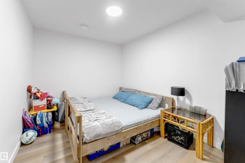 Wood-finish flooring with white walls and a ceiling-mounted light fixture - 1263 Watt Drive Sw, Edmonton, AB - Indoor Photo Showing Bedroom