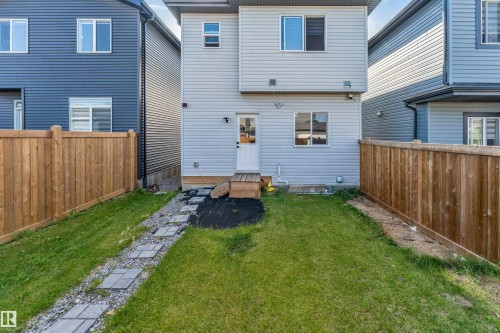 Expansive backyard with a wooden fence, paver stone pathway, and a wooden deck - 1263 Watt Drive Sw, Edmonton, AB - Outdoor With Exterior