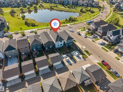 Residential property with paved streets and sidewalks, surrounded by green spaces and a water feature - 1263 Watt Drive Sw, Edmonton, AB - Outdoor With View