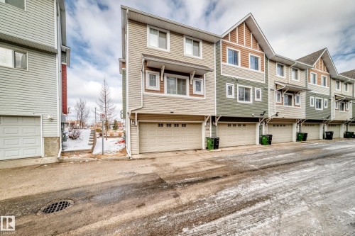 Multi-level townhome featuring a two-car garage, horizontal siding, and gabled rooflines - #138 655 Tamarack Rd Nw, Edmonton, AB - Outdoor With Facade