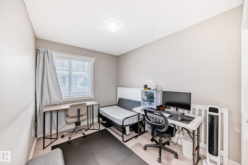 Neutral wall paint, light-toned wood-finish flooring, and a single window with blinds - #138 655 Tamarack Rd Nw, Edmonton, AB - Indoor Photo Showing Office
