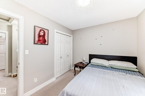 Wall-to-wall carpeting, bi-fold closet doors, and recessed lighting - #138 655 Tamarack Rd Nw, Edmonton, AB - Indoor Photo Showing Bedroom