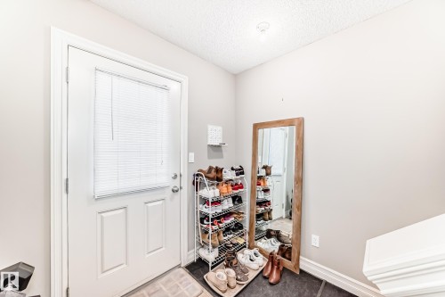 White panel door with an integrated blind, featuring a silver-tone door handle - #138 655 Tamarack Rd Nw, Edmonton, AB - Indoor Photo Showing Other Room
