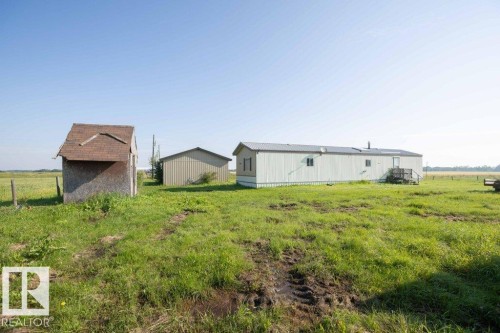 Expansive grassy terrain with a detached shed and secondary structure - 26417 Twp Rd 582, Rural Westlock County, AB - Outdoor