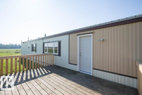 Wood deck with a natural finish, wood railing, exterior door, and exterior wall light fixture - 26417 Twp Rd 582, Rural Westlock County, AB - Outdoor With Deck Patio Veranda With Exterior