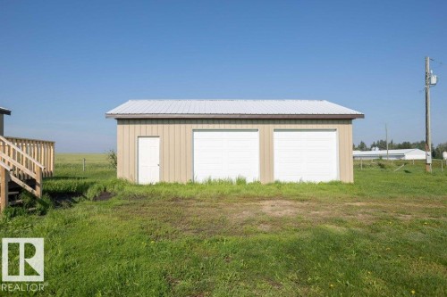 Two-car detached garage featuring a white metal roof and tan siding - 26417 Twp Rd 582, Rural Westlock County, AB - Outdoor