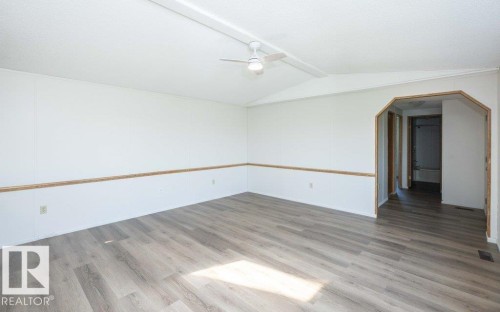 Interior featuring wood-finish flooring, white walls with natural wood trim, and a ceiling fan - 26417 Twp Rd 582, Rural Westlock County, AB - Indoor Photo Showing Other Room