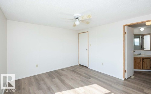 Spacious room featuring wood-finish flooring, white walls, and a ceiling fan - 26417 Twp Rd 582, Rural Westlock County, AB - Indoor Photo Showing Other Room