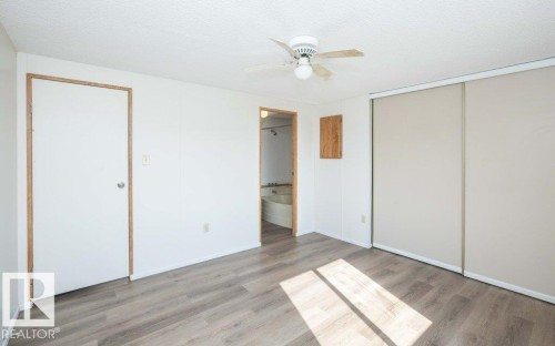 Wood-finish flooring, ceiling fan, and sliding closet doors - 26417 Twp Rd 582, Rural Westlock County, AB - Indoor Photo Showing Other Room