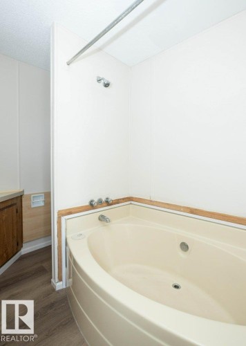 Corner soaking tub with integrated jets and chrome fixtures - 26417 Twp Rd 582, Rural Westlock County, AB - Indoor Photo Showing Bathroom