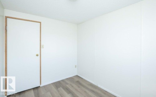 Wood-finish flooring with white wall paneling - 26417 Twp Rd 582, Rural Westlock County, AB - Indoor Photo Showing Other Room