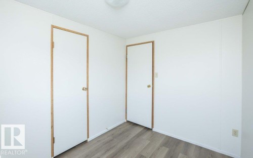 Wood-finish flooring with white paneled walls and a flush-mount ceiling light - 26417 Twp Rd 582, Rural Westlock County, AB - Indoor Photo Showing Other Room