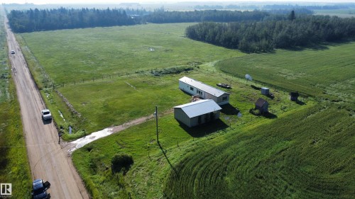 Expansive green fields, mature tree lines, and a visible dirt road - 26417 Twp Rd 582, Rural Westlock County, AB - Outdoor With View