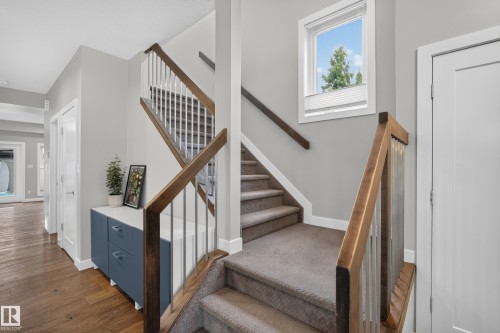 Staircase with wood handrails, metal balusters, and carpeted treads - 11018 122 Street Nw, Edmonton, AB - Indoor Photo Showing Other Room