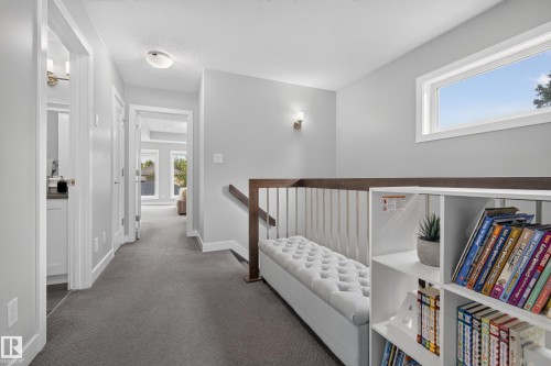 Carpeted hallway with a built-in bench, open shelving, and a prominent window - 11018 122 Street Nw, Edmonton, AB - Indoor Photo Showing Other Room