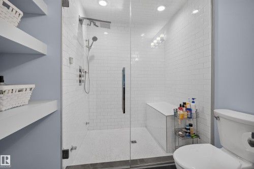 Glass-enclosed shower with subway tile surround, integrated bench seating, and dual shower heads - 11018 122 Street Nw, Edmonton, AB - Indoor Photo Showing Bathroom