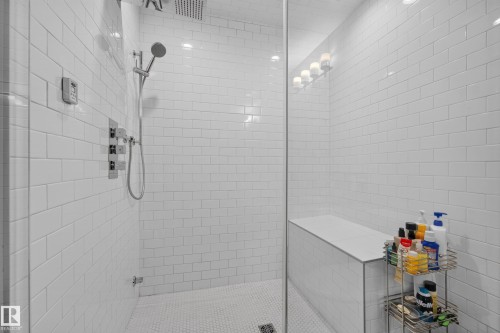 Walk-in shower with white subway tile, built-in bench, and rain showerhead - 11018 122 Street Nw, Edmonton, AB - Indoor Photo Showing Bathroom