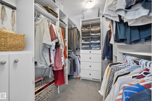 Custom closet system featuring built-in shelving, hanging rods, and a four-drawer storage unit - 11018 122 Street Nw, Edmonton, AB - Indoor With Storage