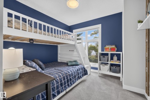 Bunk bed with integrated ladder, white window trim, light gray wall paint, dark blue accent wall, and light gray carpeting - 11018 122 Street Nw, Edmonton, AB - Indoor Photo Showing Bedroom