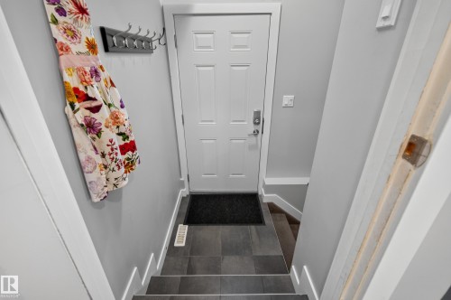 Solid core door with paneling, coat rack, and durable tile flooring - 11018 122 Street Nw, Edmonton, AB - Indoor Photo Showing Other Room