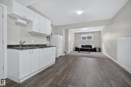 White cabinetry with a dark countertop and stainless steel sink - 11018 122 Street Nw, Edmonton, AB - Indoor Photo Showing Kitchen