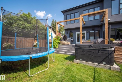 Expansive backyard with a modern tiered deck, dark stucco exterior, and a built-in hot tub - 11018 122 Street Nw, Edmonton, AB - Outdoor With Deck Patio Veranda