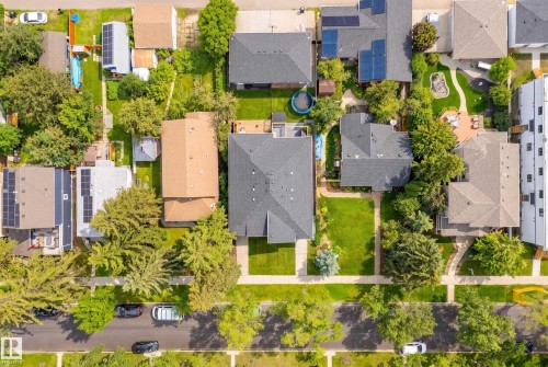 Aerial perspective showcasing a residential neighborhood with mature trees, green lawns, asphalt streets, and sidewalks - 11018 122 Street Nw, Edmonton, AB - Outdoor With View