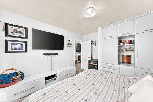 Built-in wardrobe with white cabinetry and integrated shelving - 10524 128 Avenue Nw, Edmonton, AB - Indoor