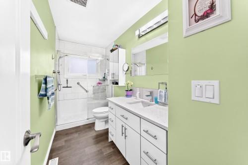 Walk-in shower with clear glass enclosure and tile surround - 10524 128 Avenue Nw, Edmonton, AB - Indoor Photo Showing Bathroom