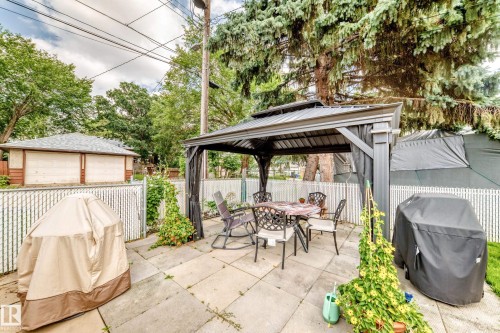 Paved patio area featuring a fixed gazebo structure and privacy fencing - 10524 128 Avenue Nw, Edmonton, AB - Outdoor With Deck Patio Veranda