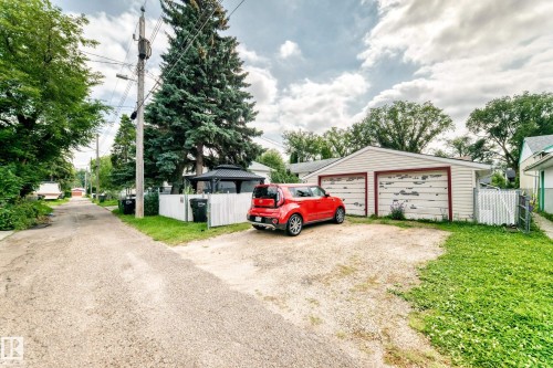 Detached two-car garage with siding exterior, gravel parking pad, and perimeter fencing - 10524 128 Avenue Nw, Edmonton, AB - Outdoor