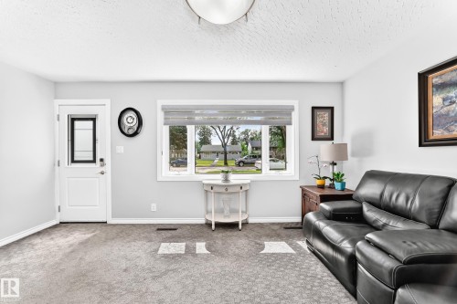 Recessed ceiling light, white trim, light gray wall paint, window with blinds, and white entry door with glass insert - 10524 128 Avenue Nw, Edmonton, AB - Indoor Photo Showing Living Room