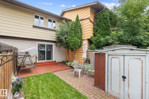 Backyard featuring a red-stained deck, sliding glass door, a brick paver patio, and a metal storage shed - 152 Woodstock Nw, Edmonton, AB - Outdoor With Deck Patio Veranda With Exterior