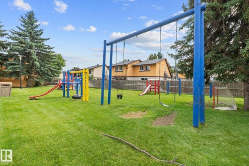 Community playground featuring swings, slides, a tire swing, and climbing structures - 152 Woodstock Nw, Edmonton, AB - Outdoor