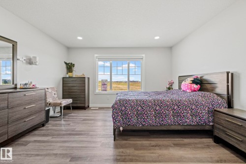 Recessed ceiling lighting, large window, wood-finish flooring, and white painted walls - 16128 31 Avenue Sw, Edmonton, AB - Indoor Photo Showing Bedroom