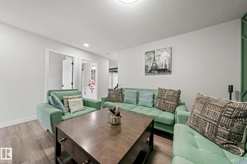 Wood-finish flooring throughout, white walls, and a recessed ceiling light - 16128 31 Avenue Sw, Edmonton, AB - Indoor Photo Showing Living Room