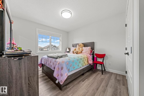 White walls, wood-finish flooring, and a multi-pane window - 16128 31 Avenue Sw, Edmonton, AB - Indoor Photo Showing Bedroom