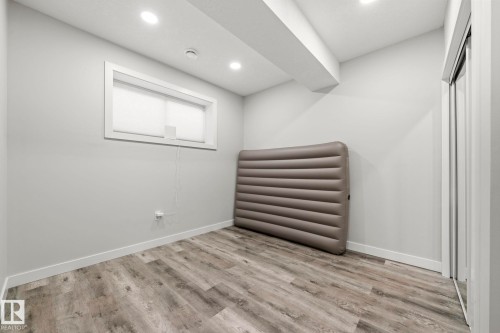 Recessed lighting, wood-finish flooring, white trim, and a white framed window - 16128 31 Avenue Sw, Edmonton, AB - Indoor Photo Showing Other Room