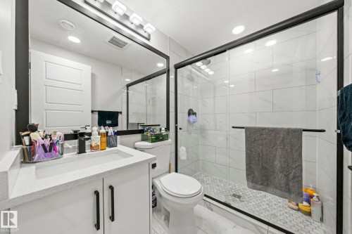 White vanity with integrated rectangular sink and matte black faucet - 16128 31 Avenue Sw, Edmonton, AB - Indoor Photo Showing Bathroom
