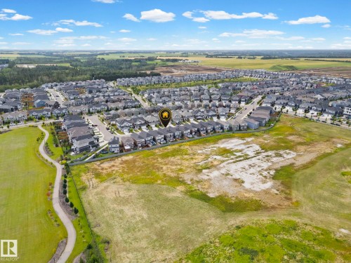 Residential neighborhood with established streets and pathways, surrounded by open green spaces and distant tree lines - 16128 31 Avenue Sw, Edmonton, AB - Outdoor With View