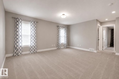 Spacious room featuring carpeting, multiple windows with blinds, a ceiling-mounted light fixture, and recessed lighting - 7274 Morgan Road Nw, Edmonton, AB - Indoor Photo Showing Other Room